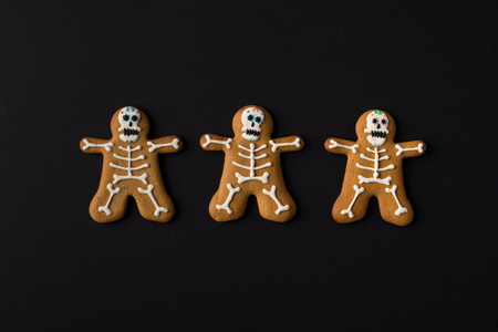 top view of halloween skeleton cookies isolated on blackの写真素材