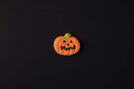 top view of tasty traditional halloween pumpkin cookie isolated on blackの写真素材