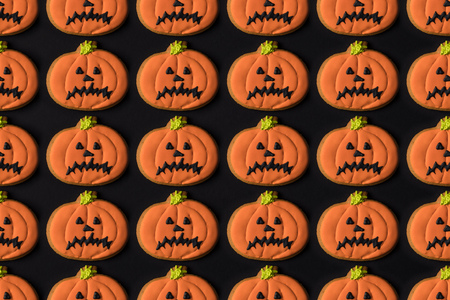 top view of tasty traditional halloween pumpkin cookies isolated on black