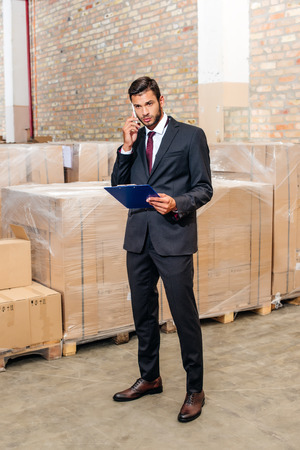 businessman talking by phone at warehouseの写真素材
