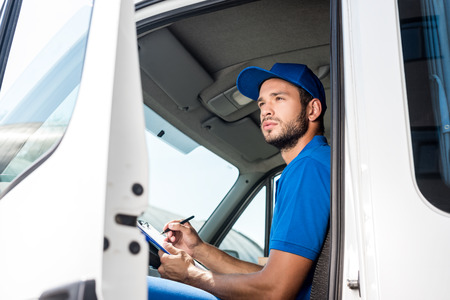 delivery man filling in documentsの写真素材