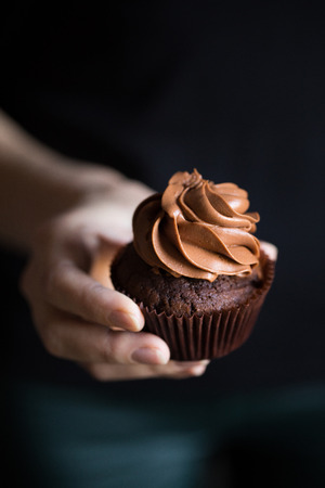hand with chocolate cupcakeの写真素材