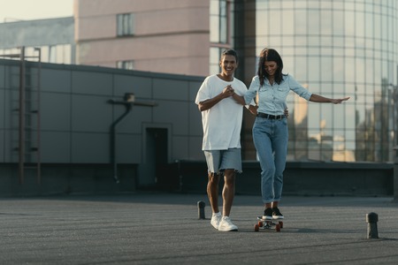 young woman learning to ride skateboardの写真素材