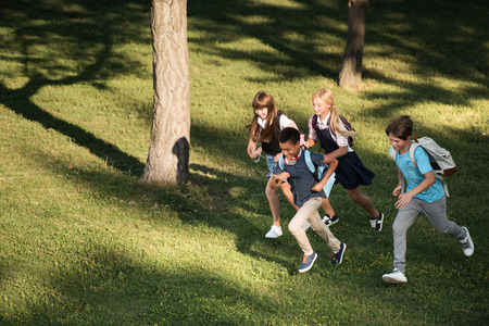 multiethnic teenagers running in parkの写真素材