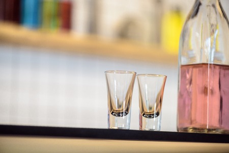 close-up view of empty glasses and bottle with alcoholic beverage on bar counterの写真素材