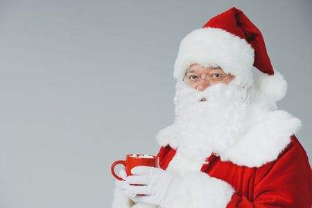 santa drinking hot chocolate with marshmallowsの写真素材