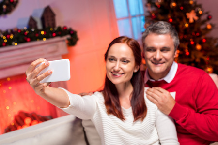 couple taking selfie with christmas treeの写真素材