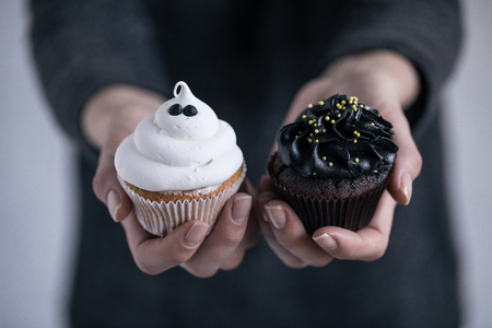 person holding halloween cupcakesの写真素材