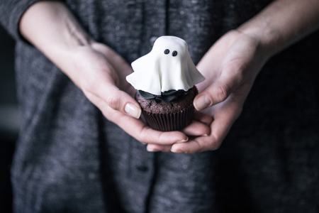 person holding halloween cupcakeの写真素材