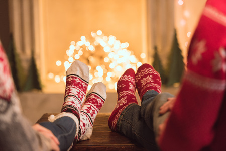 couple in knitted socks near fireplaceの写真素材