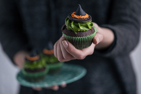 person holding halloween cupcakeの写真素材