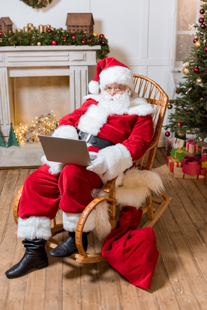 santa claus with laptop at homeの写真素材