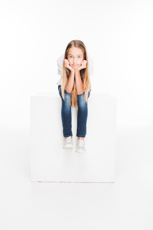 child sitting on white cubeの写真素材