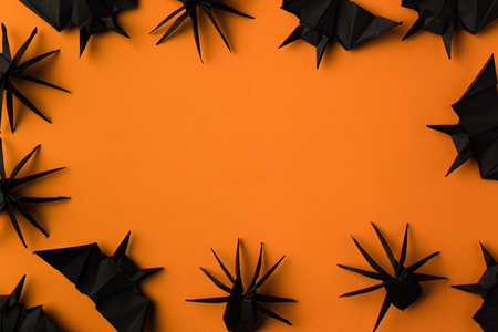halloween frame with black origami spiders and bats, isolated on orangeの写真素材