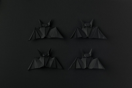 four black origami bats for halloween, isolated on blackの写真素材