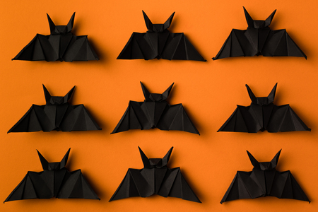 halloween texture with black origami bats, isolated on orangeの写真素材