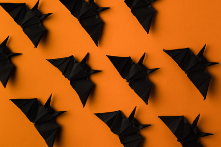 halloween texture with black origami bats, isolated on orangeの写真素材