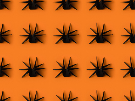 halloween texture with black origami spiders, isolated on orangeの写真素材