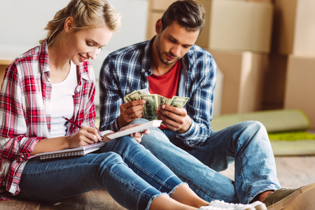young couple counting moneyの写真素材