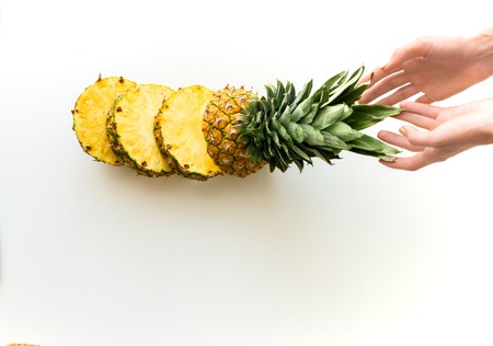 hands with sliced fresh pineapple