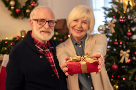 senior couple holding giftの写真素材