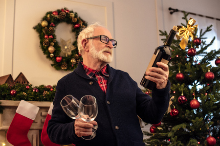 senior man with wine at christmastimeの写真素材