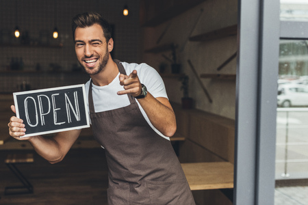 waiter holding chalkboard with open word
