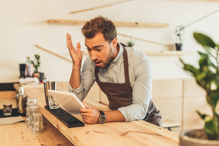 barista using tablet in coffee shopの写真素材