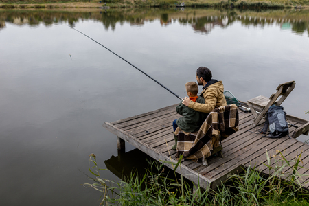 father and son fishing on pier