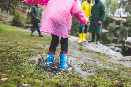 kid jumping in muddy puddleの写真素材