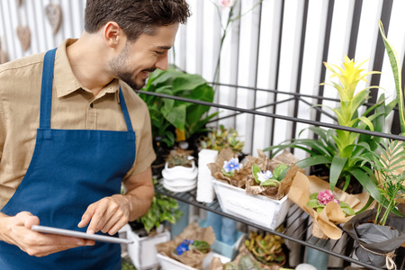 male florist with digital tabletの写真素材