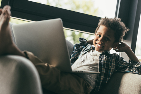 boy with laptop in armchairの写真素材