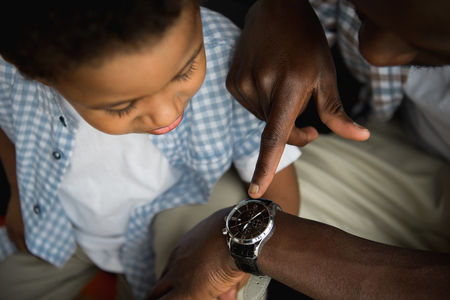 father and son checking wristwatchの写真素材