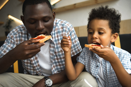 father and son eating toastsの写真素材