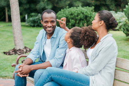 african american family resting on benchの写真素材