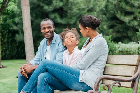 african american family resting on benchの写真素材