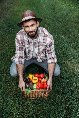 farmer holding basket with vegetablesの写真素材