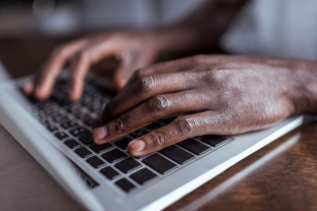 afro man typing on laptop