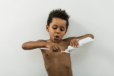 kid applying tooth paste on brushの写真素材