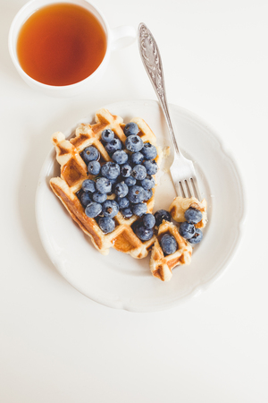waffle with blueberries and cup of teaの写真素材