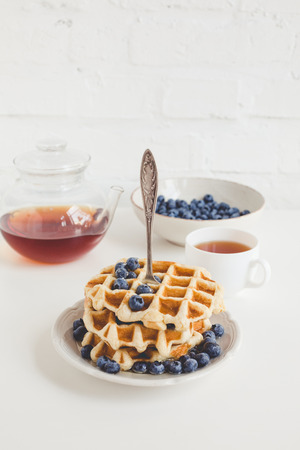 tasty breakfast of waffles with blueberries and teaの写真素材