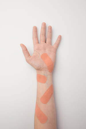 Cropped image of hand with many beige plasters の写真素材