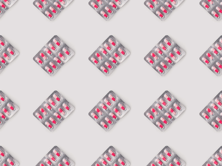 Set of blister packs with red and pink pills isolated on whiteの写真素材