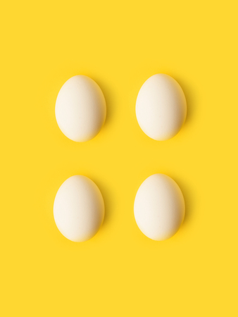Top view of Four chicken eggs isolated on yellow