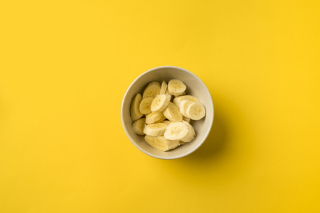 Top view of Plate with cut bananas isolated on yellowの写真素材