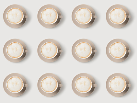 top view of pattern of cups with latte on white surfaceの写真素材