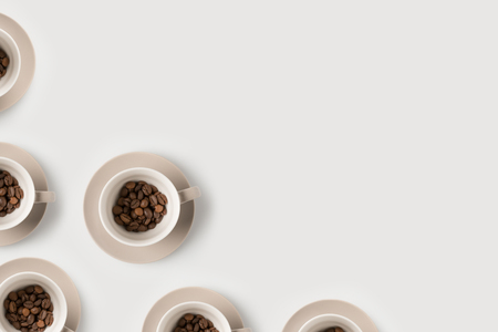 top view of coffee beans in cups composition on white surfaceの写真素材