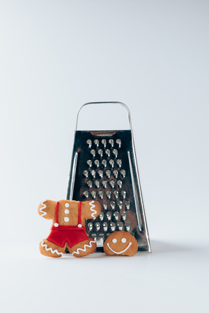 grater and broken gingerbread man, on white  