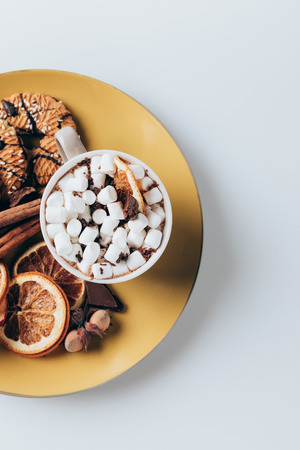 top view of plate with cookies and cup of hot cacao with marshmallows, on white  の写真素材