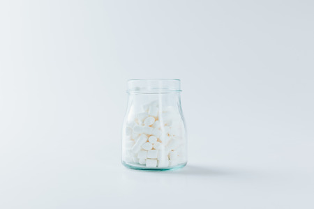glass jar with sweet marshmallows, on white の写真素材